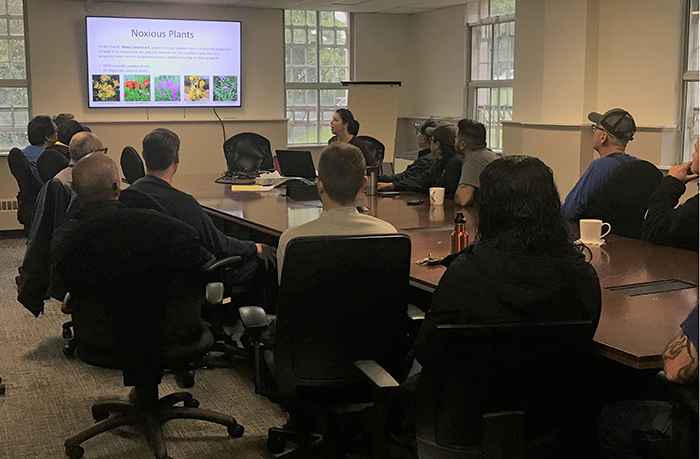 People sat around a board room table watching a power point presentation