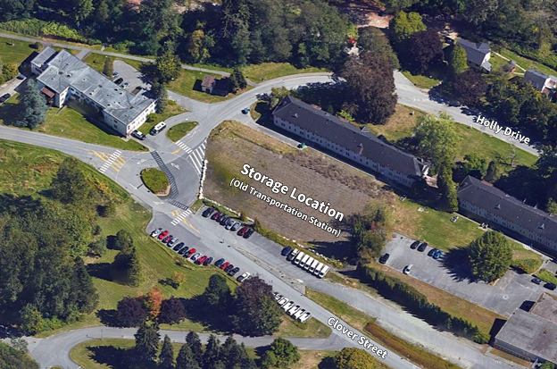 An aerial view of an area showing a storage location labeled 'Storage Location (Old Transportation Station)' situated between Holly Drive and Clover Street, with nearby buildings, parking lots, and surrounding greenery.